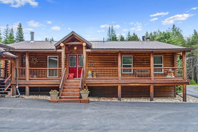 312 Pickett Rd, Ione, WA 99139 - log home featuring a porch, metal roof, and log exterior