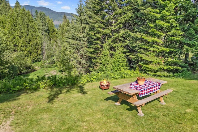 312 Pickett Rd, Ione, WA 99139 - view of grassy yard with an outdoor fire pit, a forest view, and a mountain view