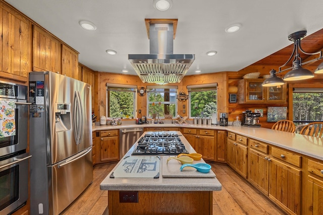 312 Pickett Rd, Ione, WA 99139 - kitchen featuring appliances with stainless steel finishes, brown cabinets, island exhaust hood, a center island, and healthy amount of natural light