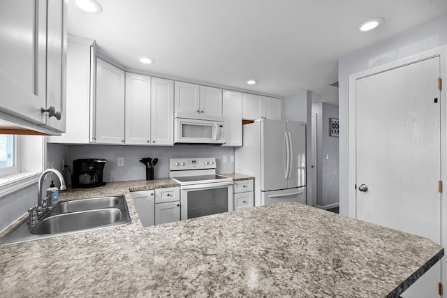 4238 E 24th Ave, Spokane, WA 99223 - kitchen featuring white appliances, a sink, white cabinetry, recessed lighting, and a peninsula