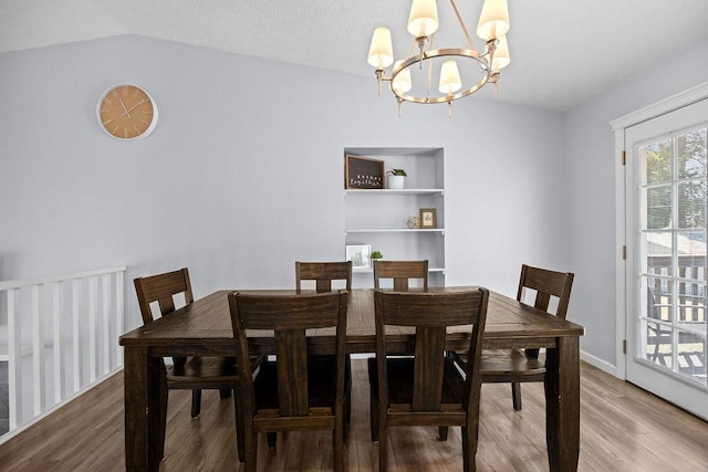 4238 E 24th Ave, Spokane, WA 99223 - dining room featuring a chandelier, wood finished floors, vaulted ceiling, built in shelves, and baseboards