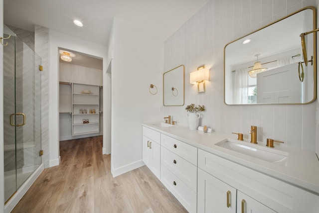 1217 E Granary Ct, Spokane, WA 99208 - bathroom with a stall shower, double vanity, wood finished floors, baseboards, and a spacious closet