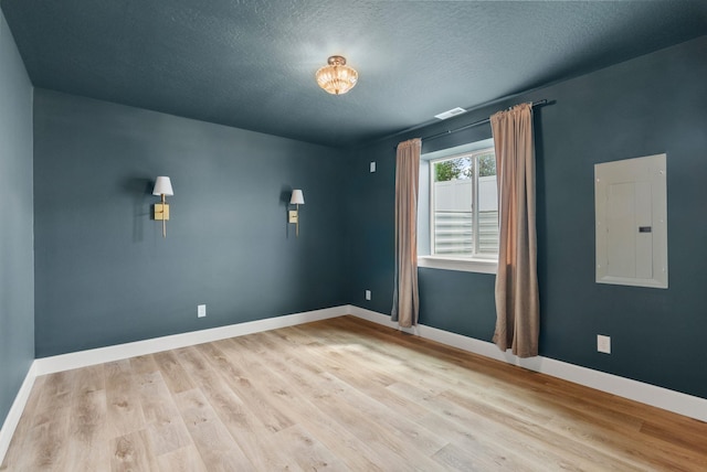 1217 E Granary Ct, Spokane, WA 99208 - empty room with electric panel, wood finished floors, baseboards, and a textured ceiling