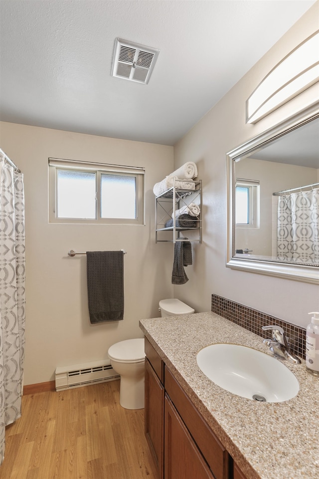 3014 S Perry St Unit 3014, Spokane, WA 99203 - full bath with a baseboard radiator, vanity, toilet, and healthy amount of natural light