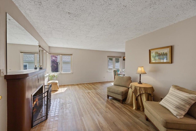 904 E 40th Ave, Spokane, WA 99203 - sitting room with wood finished floors, a warm lit fireplace, and a textured ceiling