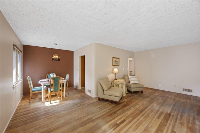 904 E 40th Ave, Spokane, WA 99203 - sitting room featuring wood finished floors, a textured ceiling, and a chandelier