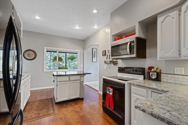 6913 S Ben Burr Rd, Spokane, WA 99223 - kitchen with range with electric stovetop, freestanding refrigerator, stainless steel microwave, dark wood-style flooring, and white cabinetry