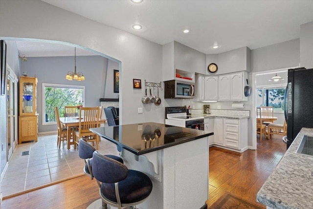 6913 S Ben Burr Rd, Spokane, WA 99223 - kitchen featuring electric stove, freestanding refrigerator, stainless steel microwave, a chandelier, and white cabinetry