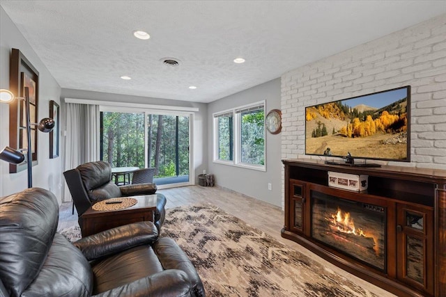 6913 S Ben Burr Rd, Spokane, WA 99223 - living area featuring recessed lighting, a fireplace, wood finished floors, and a textured ceiling