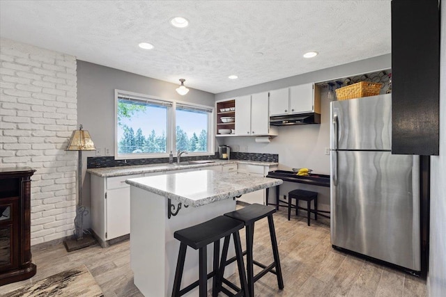 6913 S Ben Burr Rd, Spokane, WA 99223 - kitchen featuring freestanding refrigerator, range, a textured ceiling, white cabinets, and light wood-type flooring