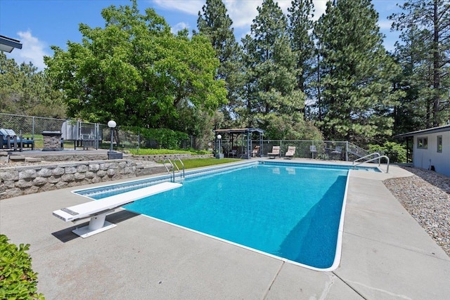 6913 S Ben Burr Rd, Spokane, WA 99223 - view of swimming pool with a patio area, a diving board, and view of scattered trees