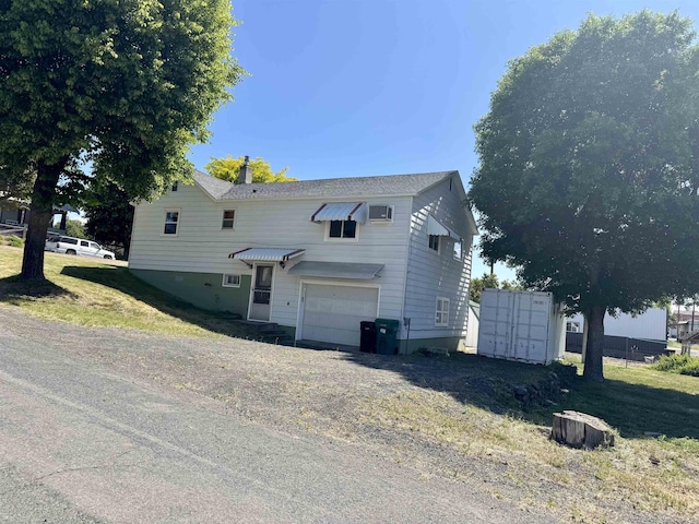 216 NW Cole Ave, Wilbur, WA 99185 - view of side of property featuring mail area, a garage, a chimney, and driveway