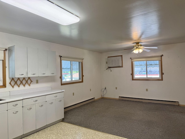 216 NW Cole Ave, Wilbur, WA 99185 - kitchen featuring baseboard heating, light countertops, a ceiling fan, and white cabinetry
