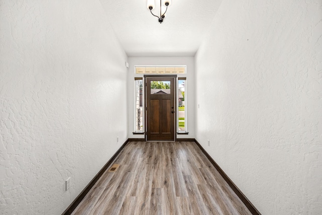 10697 N Crimson Dr, Hayden, ID 83835 - entrance foyer with wood finished floors, a textured wall, and baseboards