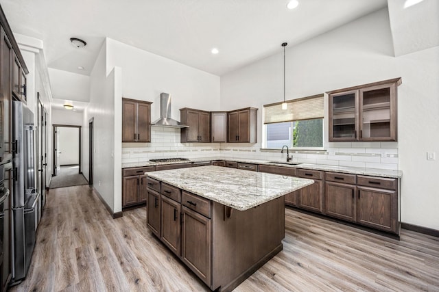 10697 N Crimson Dr, Hayden, ID 83835 - kitchen with wall chimney exhaust hood, a sink, appliances with stainless steel finishes, light wood-style floors, and a kitchen island