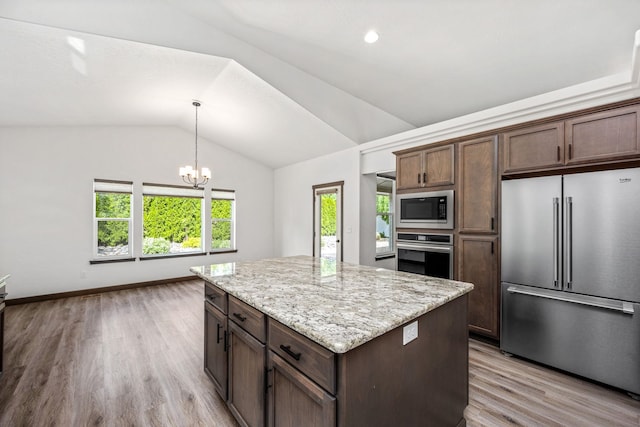 10697 N Crimson Dr, Hayden, ID 83835 - kitchen with stainless steel appliances, vaulted ceiling, light wood finished floors, a kitchen island, and a chandelier