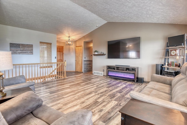 6930 N N Lynden Ln, Otis Orchards, WA 99027 - living room featuring lofted ceiling, wood finished floors, a textured ceiling, and baseboards