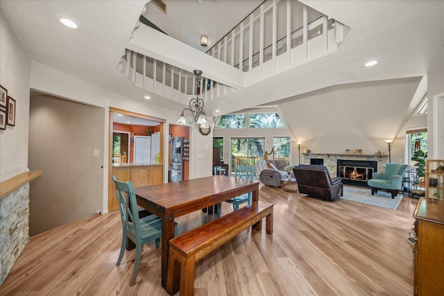 1411 W Spring Ln, Spokane, WA 99218 - dining area featuring a fireplace, plenty of natural light, light wood-style flooring, recessed lighting, and a towering ceiling