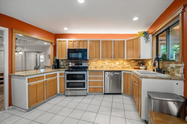 1411 W Spring Ln, Spokane, WA 99218 - kitchen with appliances with stainless steel finishes, tasteful backsplash, light stone counters, recessed lighting, and light tile patterned flooring