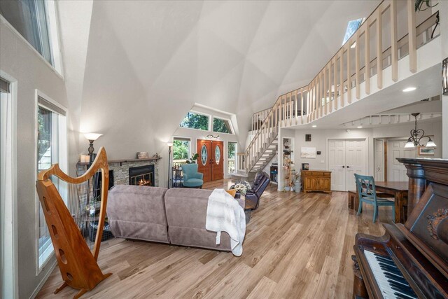 1411 W Spring Ln, Spokane, WA 99218 - living area featuring a towering ceiling, a stone fireplace, wood finished floors, and stairs