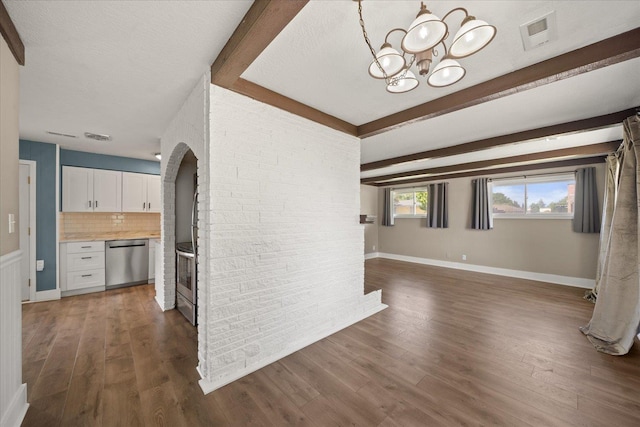 519 N Bannen Rd, Spokane Valley, WA 99216 - kitchen with stainless steel dishwasher, white cabinetry, arched walkways, beamed ceiling, and a chandelier