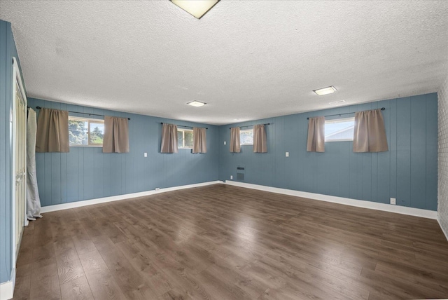 519 N Bannen Rd, Spokane Valley, WA 99216 - below grade area featuring wood finished floors, baseboards, a textured ceiling, and wood walls