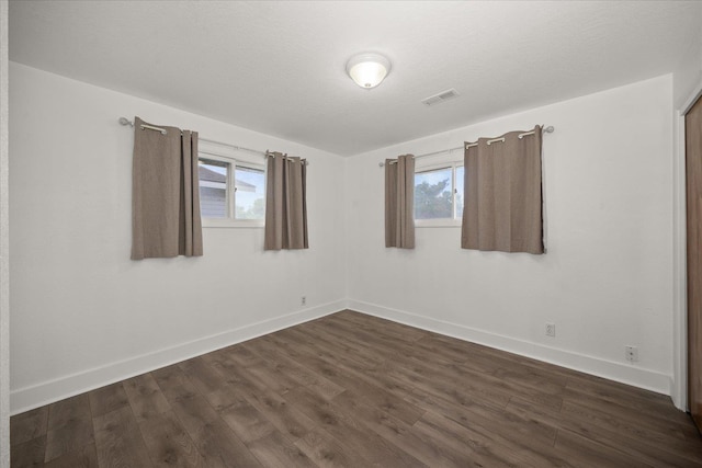 519 N Bannen Rd, Spokane Valley, WA 99216 - unfurnished room with baseboards, dark wood-type flooring, and healthy amount of natural light