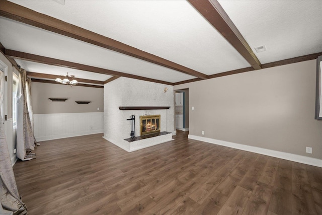 519 N Bannen Rd, Spokane Valley, WA 99216 - unfurnished living room with beam ceiling, wood finished floors, a chandelier, wainscoting, and a fireplace