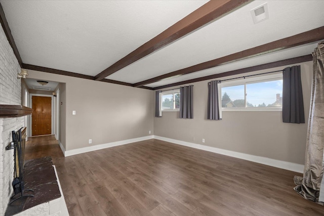 519 N Bannen Rd, Spokane Valley, WA 99216 - unfurnished living room with beamed ceiling, baseboards, dark wood finished floors, and a brick fireplace