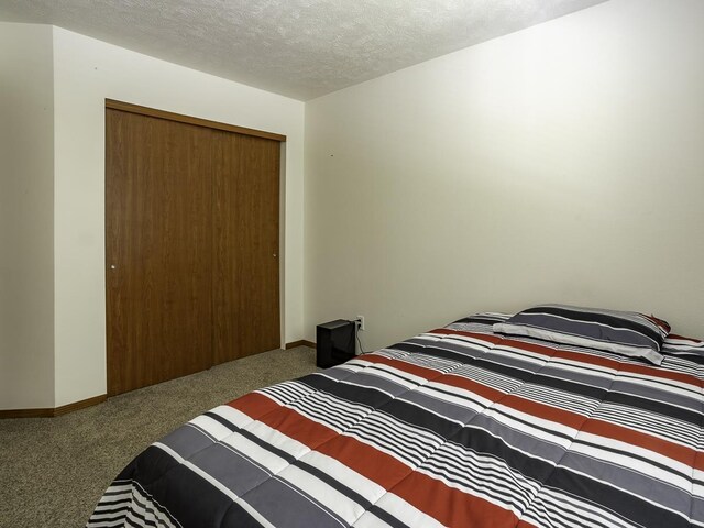 9705 E 4th Ave Unit 9707, Spokane Valley, WA 99206 - bedroom featuring carpet floors, a textured ceiling, a closet, and baseboards