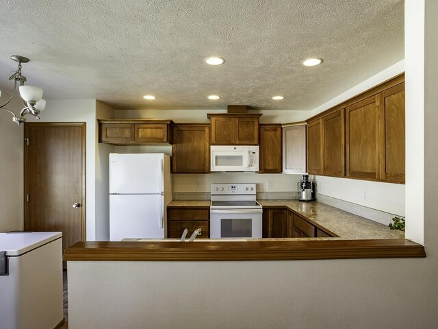 9705 E 4th Ave Unit 9707, Spokane Valley, WA 99206 - kitchen featuring white appliances, a chandelier, recessed lighting, a peninsula, and brown cabinetry