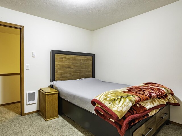 9705 E 4th Ave Unit 9707, Spokane Valley, WA 99206 - carpeted bedroom with baseboards and a textured ceiling