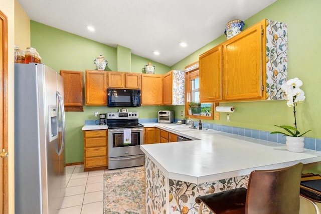 23823 E Garland Ave, Otis Orchards, WA 99027 - kitchen with stainless steel appliances, a peninsula, lofted ceiling, light countertops, and light tile patterned floors