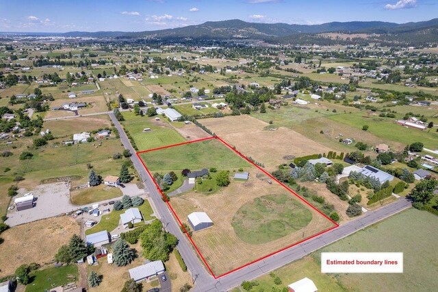 23823 E Garland Ave, Otis Orchards, WA 99027 - aerial overview of property's location featuring property boundaries highlighted and a mountain backdrop