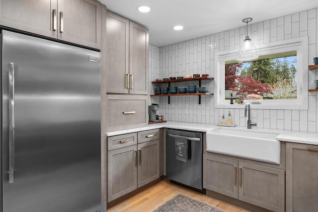 4318 S Magnolia St, Spokane, WA 99203 - kitchen featuring appliances with stainless steel finishes, a sink, decorative backsplash, light wood-style floors, and open shelves
