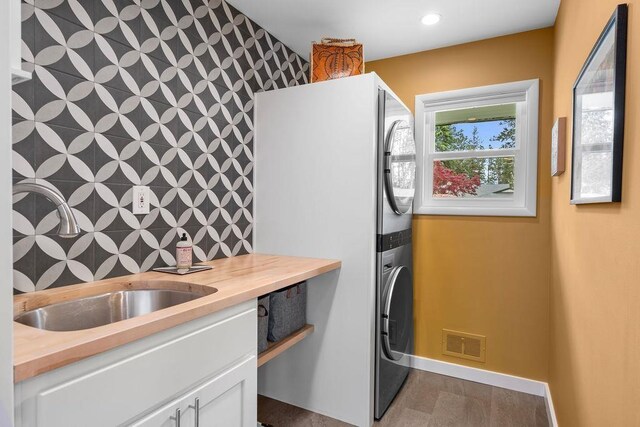 4318 S Magnolia St, Spokane, WA 99203 - kitchen with stacked washer / dryer, wood counters, white cabinets, and baseboards
