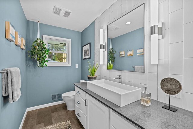 4318 S Magnolia St, Spokane, WA 99203 - bathroom with toilet, vanity, baseboards, and backsplash