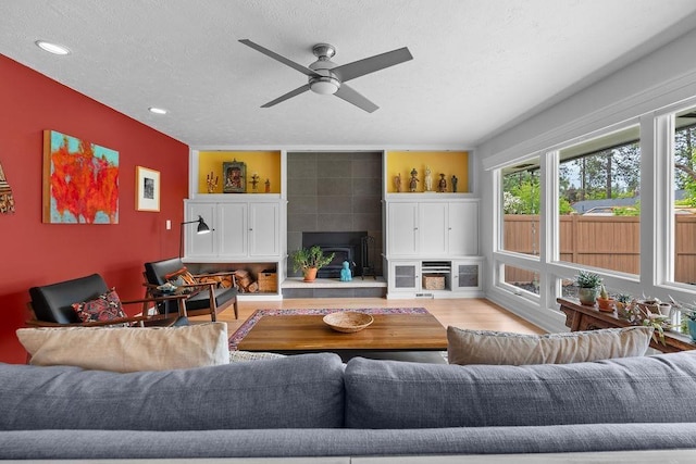 4318 S Magnolia St, Spokane, WA 99203 - living area featuring a tiled fireplace, recessed lighting, wood finished floors, ceiling fan, and a textured ceiling