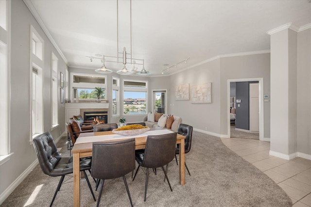 639 N Riverpoint Blvd Unit 7-W, Spokane, WA 99202 - dining room with a tile fireplace, track lighting, light tile patterned floors, baseboards, and crown molding