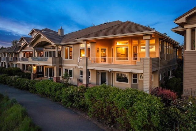 639 N Riverpoint Blvd Unit 7-W, Spokane, WA 99202 - back of house at dusk with a chimney and a balcony