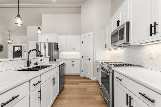 1616 S Morningside Heights Dr, Greenacres, WA 99016 - kitchen with stainless steel appliances, a sink, light wood finished floors, tasteful backsplash, and pendant lighting