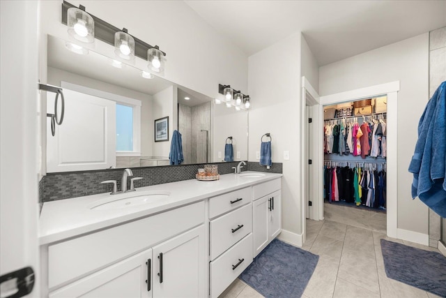 1616 S Morningside Heights Dr, Greenacres, WA 99016 - full bathroom with double vanity, a walk in closet, a shower with shower door, tile patterned floors, and baseboards