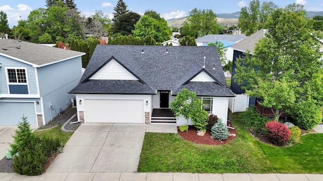 415 S Mckee St, Spokane Valley, WA 99016 - traditional-style house with roof with shingles, driveway, a garage, a front lawn, and stone siding