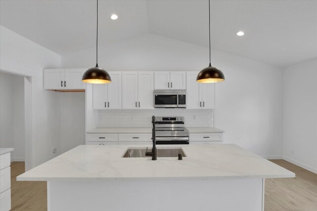 415 S Mckee St, Spokane Valley, WA 99016 - kitchen featuring appliances with stainless steel finishes, a sink, backsplash, light stone countertops, and white cabinetry