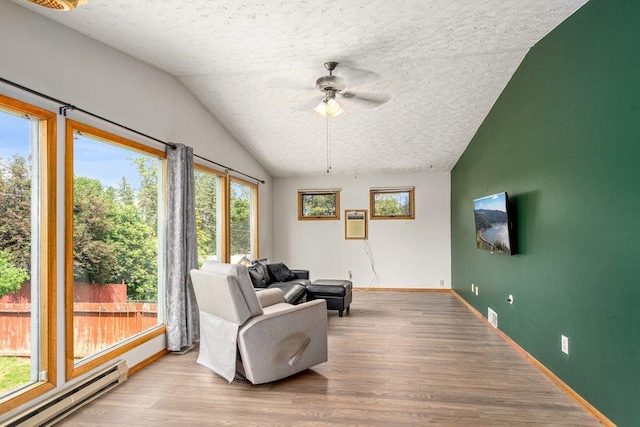 3225 E 16th Ave, Spokane, WA 99223 - sitting room featuring a baseboard heating unit, a ceiling fan, wood finished floors, lofted ceiling, and a textured ceiling