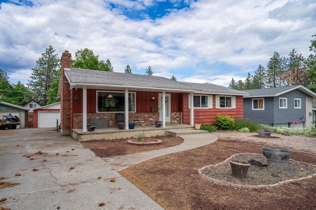 3225 E 16th Ave, Spokane, WA 99223 - single story home featuring a porch, a chimney, an outbuilding, a detached garage, and board and batten siding