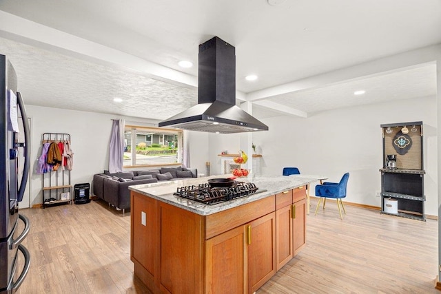 3225 E 16th Ave, Spokane, WA 99223 - kitchen with island range hood, gas stovetop, light wood finished floors, freestanding refrigerator, and a kitchen island