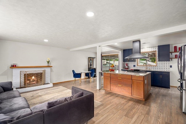 3225 E 16th Ave, Spokane, WA 99223 - living area featuring a textured ceiling, wood finished floors, a fireplace, recessed lighting, and baseboards