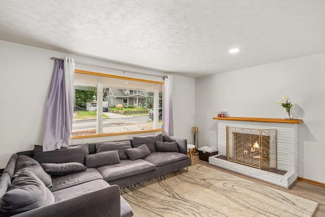 3225 E 16th Ave, Spokane, WA 99223 - living room with wood finished floors, a textured ceiling, a brick fireplace, recessed lighting, and baseboards