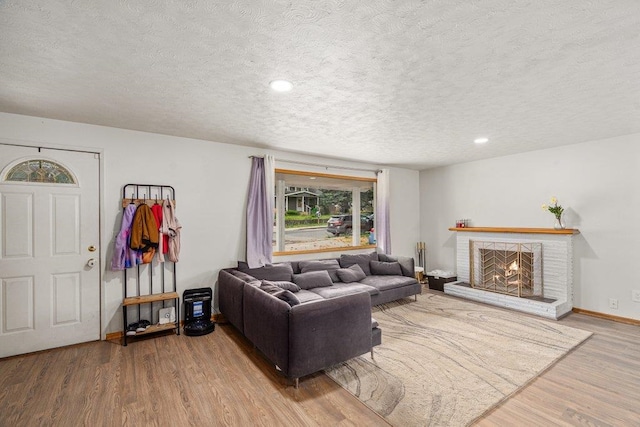 3225 E 16th Ave, Spokane, WA 99223 - living room featuring a textured ceiling, wood finished floors, a brick fireplace, baseboards, and recessed lighting